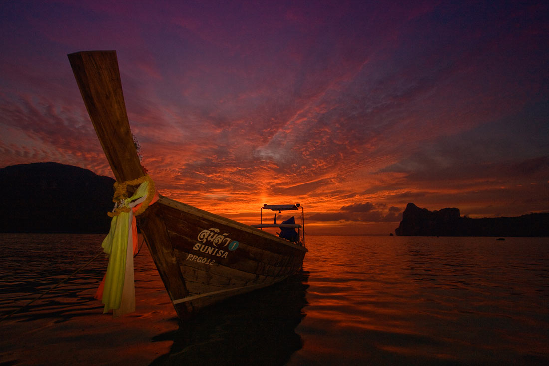 Longtail boat on sunset